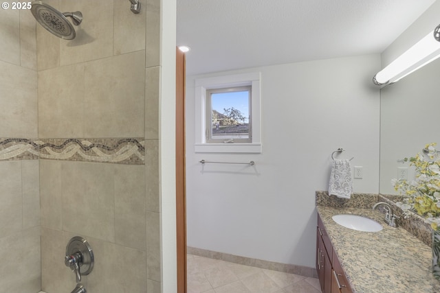 bathroom featuring tiled shower / bath, tile patterned floors, and vanity