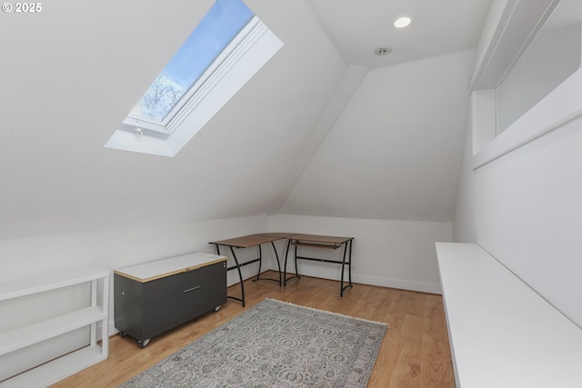 bonus room featuring hardwood / wood-style floors and vaulted ceiling with skylight