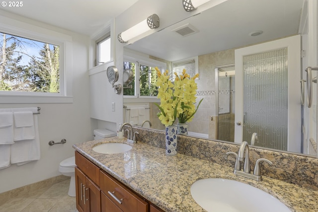 bathroom with toilet, vanity, tile patterned flooring, and walk in shower