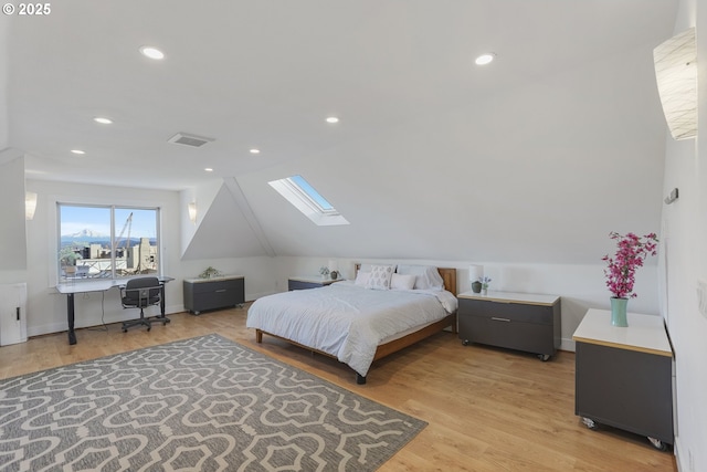 bedroom with light wood-type flooring and vaulted ceiling