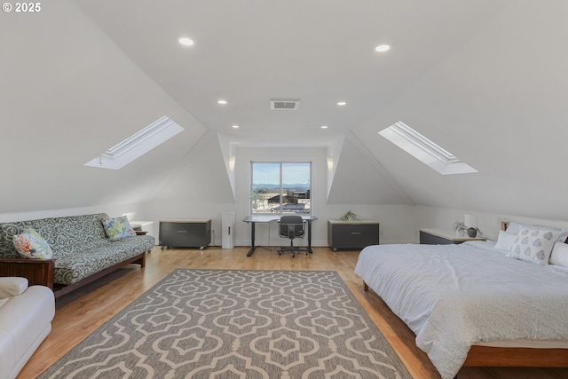 bedroom featuring hardwood / wood-style floors and vaulted ceiling with skylight