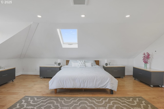 bedroom featuring light wood-type flooring and vaulted ceiling with skylight