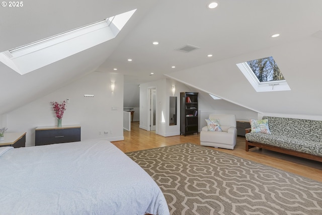 bedroom with hardwood / wood-style floors and vaulted ceiling with skylight