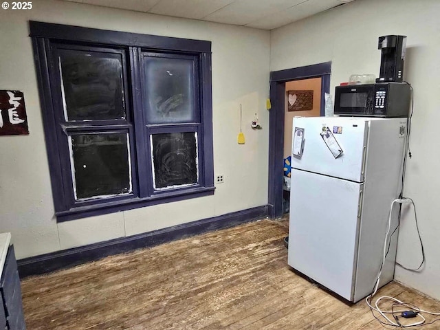 kitchen with white fridge, hardwood / wood-style floors, and a paneled ceiling