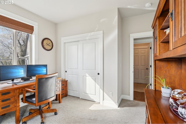 office area with baseboards and light carpet