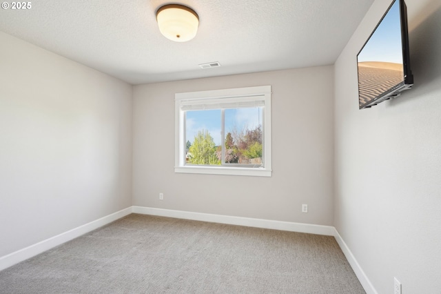unfurnished room featuring visible vents, baseboards, carpet floors, and a textured ceiling