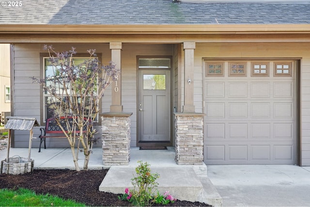 doorway to property featuring covered porch, a garage, and roof with shingles