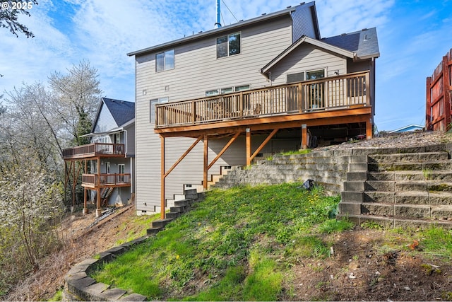 rear view of house featuring a wooden deck