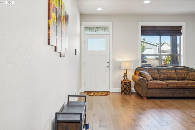 foyer featuring baseboards, recessed lighting, hardwood / wood-style floors, and stairway
