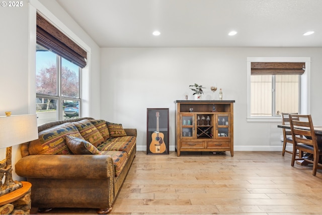 living room with light wood-style floors, baseboards, and recessed lighting