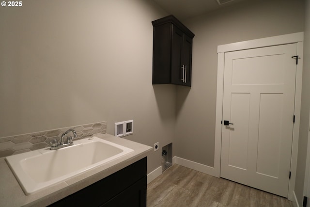 clothes washing area featuring sink, electric dryer hookup, hookup for a washing machine, cabinets, and light wood-type flooring