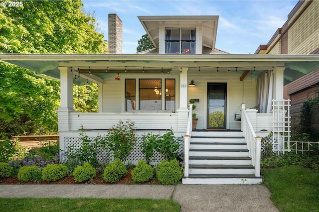 view of front facade with a porch and a chimney