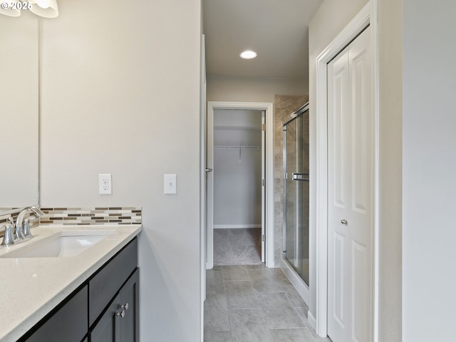 bathroom featuring tasteful backsplash, vanity, and an enclosed shower