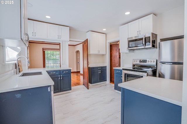 kitchen featuring blue cabinets, appliances with stainless steel finishes, sink, and white cabinets