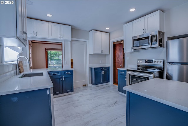 kitchen featuring blue cabinets, sink, white cabinets, and appliances with stainless steel finishes