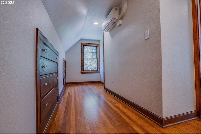 bonus room featuring lofted ceiling, wood-type flooring, and a wall unit AC