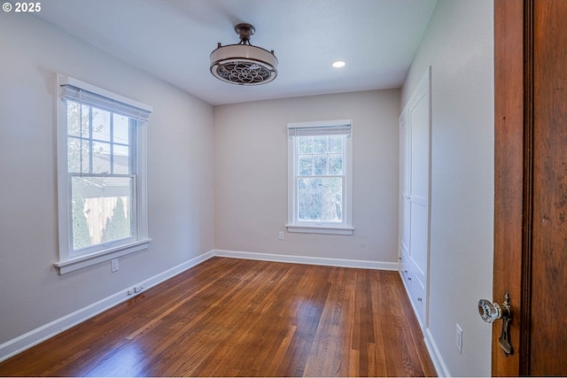 unfurnished room with dark hardwood / wood-style flooring