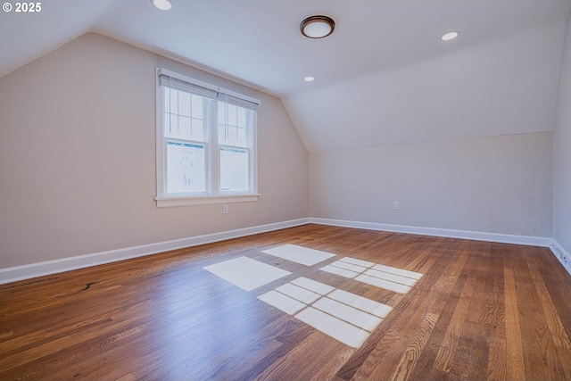 additional living space featuring vaulted ceiling and hardwood / wood-style floors