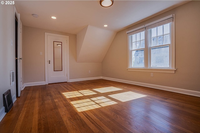 bonus room with dark wood-type flooring and vaulted ceiling