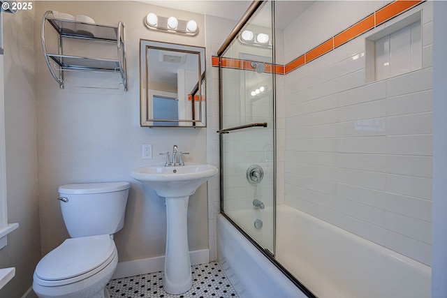 bathroom with tile patterned flooring, combined bath / shower with glass door, and toilet