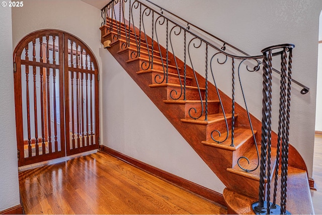 staircase with hardwood / wood-style flooring