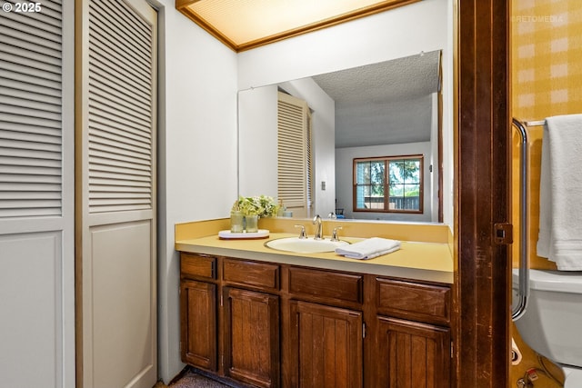 bathroom with vanity, a textured ceiling, and a closet
