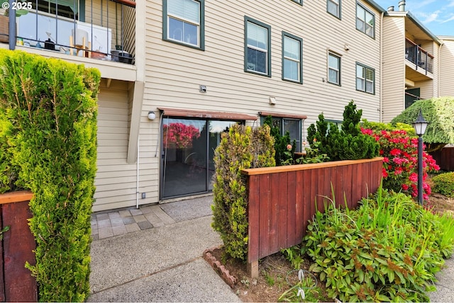 view of side of property featuring fence and a balcony