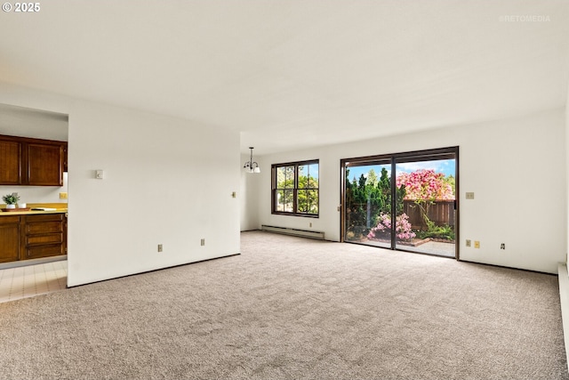 unfurnished living room with baseboard heating, light colored carpet, and baseboards