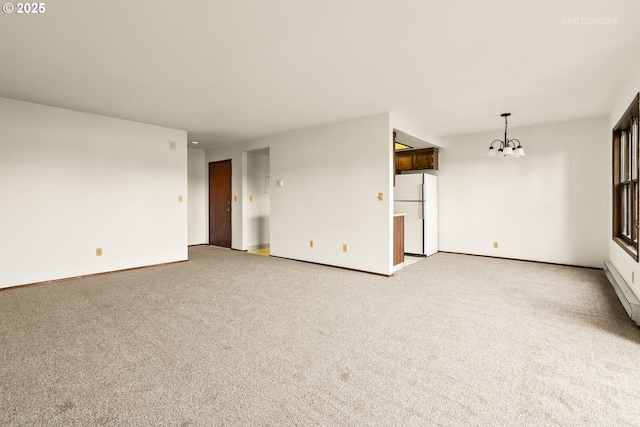 unfurnished living room featuring a chandelier, light colored carpet, and baseboards