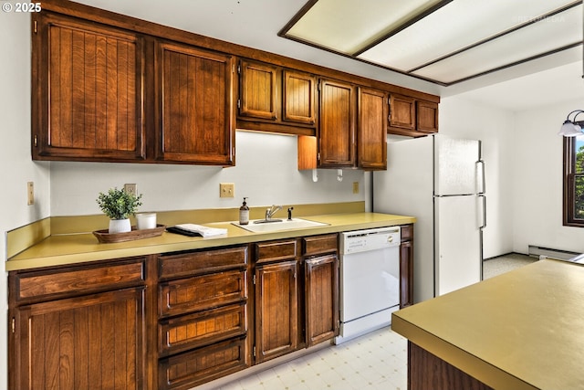kitchen with white appliances, a sink, light countertops, light flooring, and baseboard heating