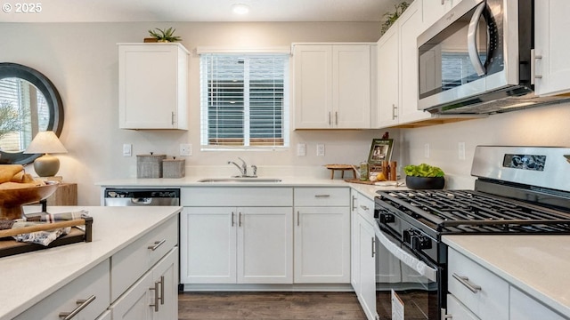 kitchen featuring appliances with stainless steel finishes, a sink, white cabinets, light countertops, and recessed lighting