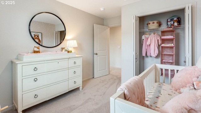 bedroom featuring light colored carpet, baseboards, and a closet