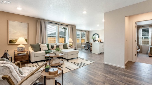 living room with baseboards, recessed lighting, wood finished floors, and a textured ceiling