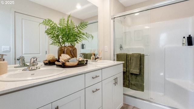 full bathroom featuring a stall shower and double vanity