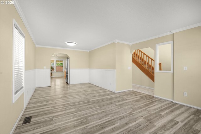 1255 NE 17th Ave, Hillsboro, OR 97124 - unfurnished room with arched walkways, light wood-type flooring, a wainscoted wall, ornamental molding, and stairway