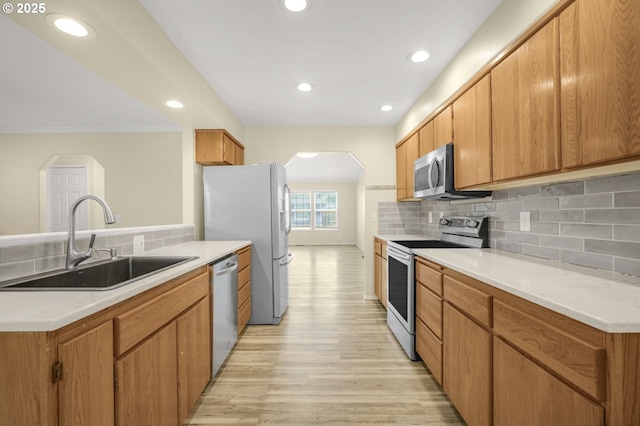 1255 NE 17th Ave, Hillsboro, OR 97124 - kitchen featuring appliances with stainless steel finishes, arched walkways, tasteful backsplash, light wood-type flooring, and light countertops