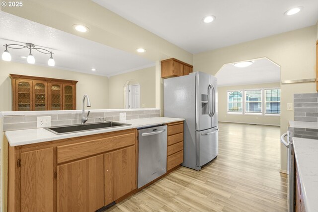 1255 NE 17th Ave, Hillsboro, OR 97124 - kitchen featuring stainless steel appliances, light countertops, light wood finished floors, arched walkways, and recessed lighting