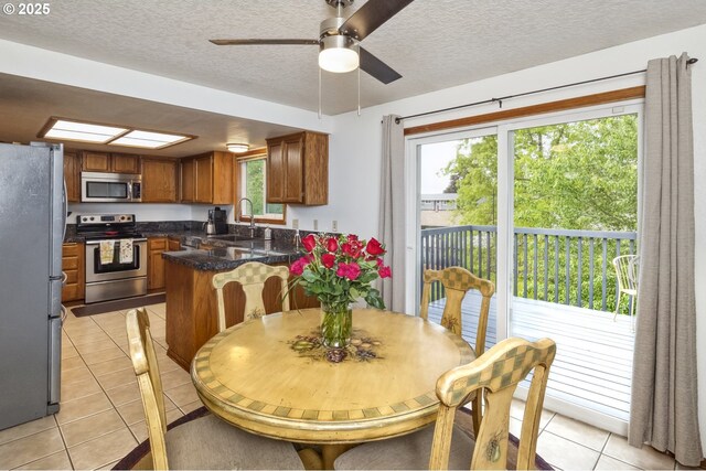 dining area with light tile patterned floors, a textured ceiling, and ceiling fan