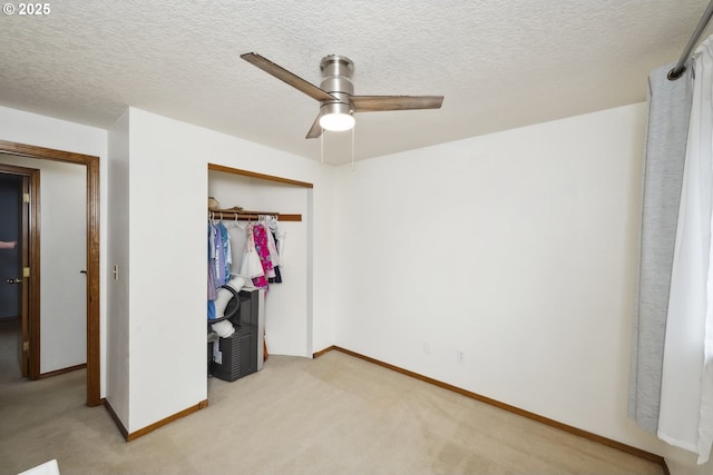 unfurnished bedroom featuring a closet, baseboards, light colored carpet, and a textured ceiling