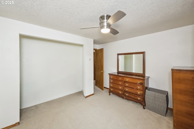 bedroom with light colored carpet, a closet, ceiling fan, and a textured ceiling