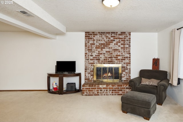carpeted living room with a brick fireplace and a textured ceiling