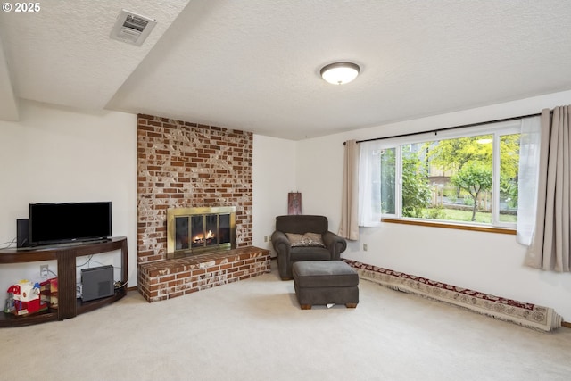 living area with a textured ceiling, a brick fireplace, and carpet