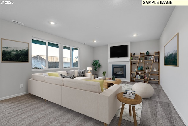 living room featuring a glass covered fireplace, baseboards, visible vents, and carpet flooring