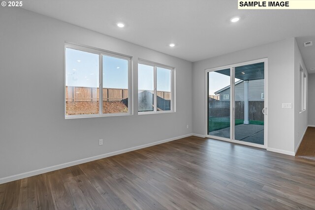 spare room with visible vents, baseboards, wood finished floors, and recessed lighting