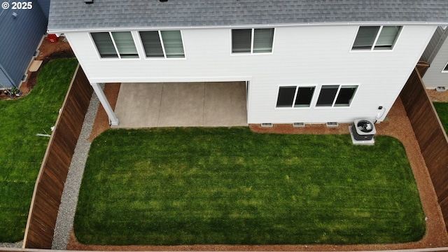 exterior space with roof with shingles, a yard, and central air condition unit