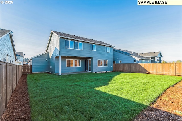 back of house with a fenced backyard and a lawn