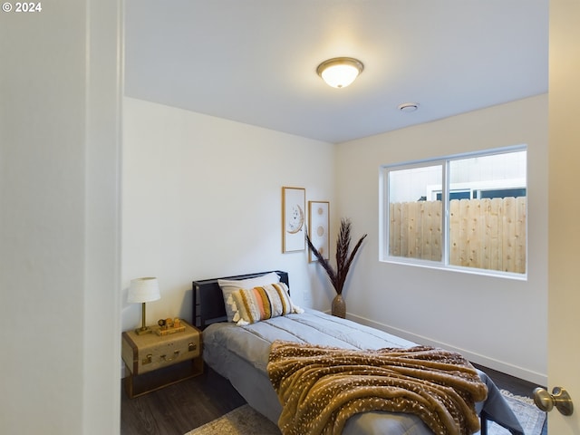 bedroom with baseboards and dark wood-style flooring