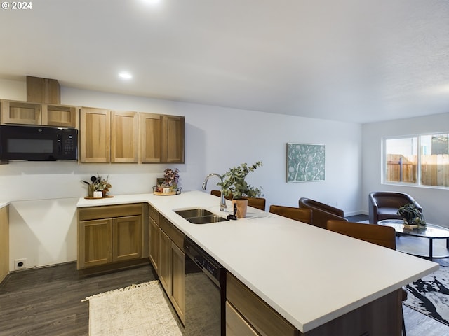 kitchen featuring dark wood-type flooring, black appliances, a sink, a peninsula, and light countertops