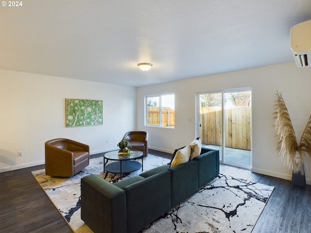 living room with a wall mounted AC, baseboards, and wood finished floors