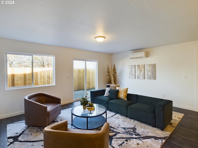 living room with baseboards, a wall unit AC, and wood finished floors